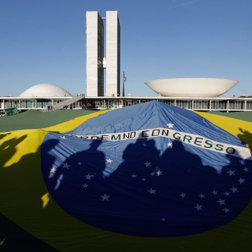 Demonstrators open a Brazil's flag